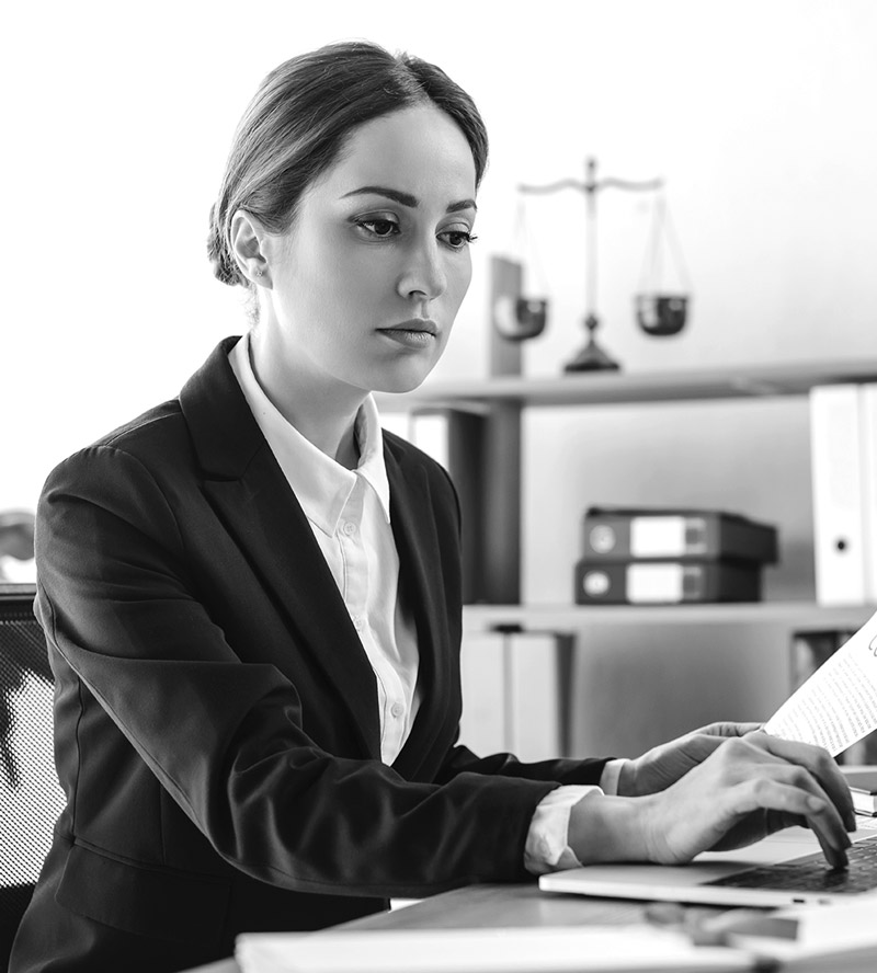 A woman working at her desk with her laptop in front of her